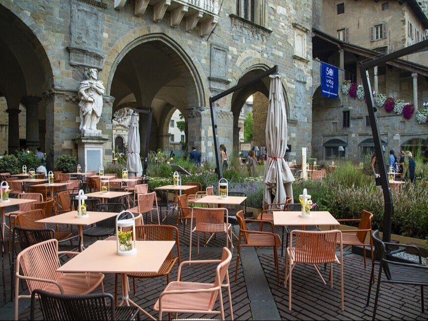 Café terrace in historic area with Pedrali Elliot tables, Pedrali Tribeca chairs and Giravolta portable lamp