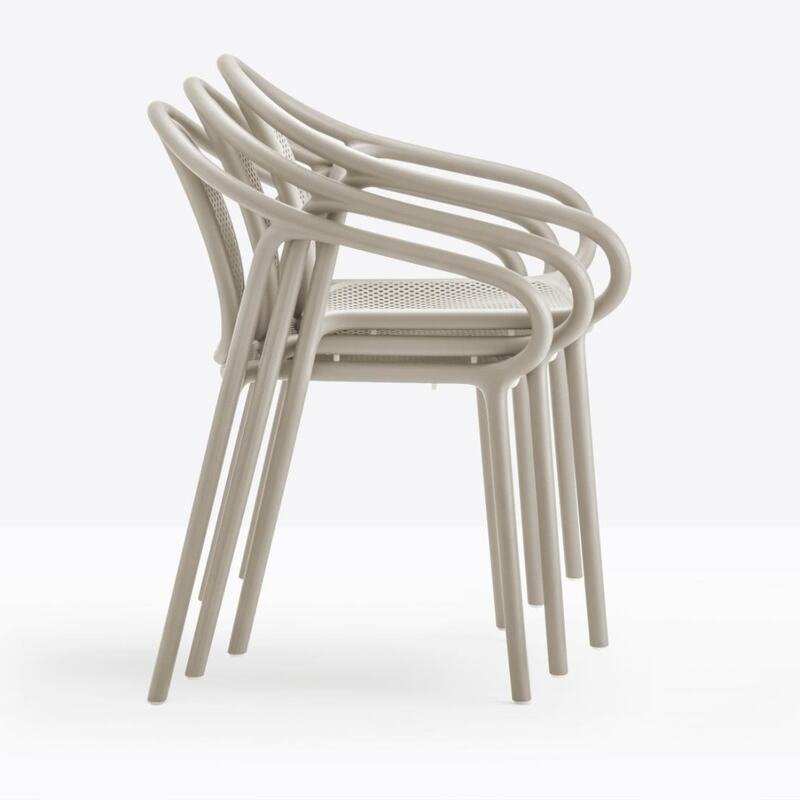 Three Pedrali Remind stackable chairs in light beige polypropylene, with perforated backrest and seat, seen from the side on a white background. 