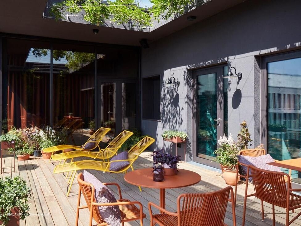 Yellow and orange Pedrali Nolita chairs and loungers outside a hotel 
