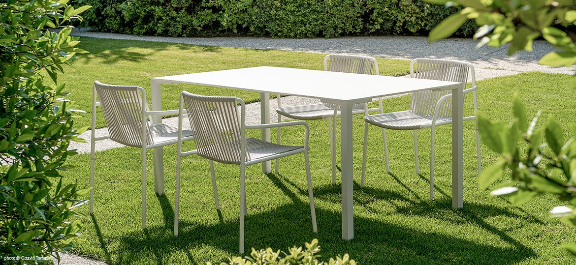 Togo table and Tribeca Stoneli chairs in a garden setting